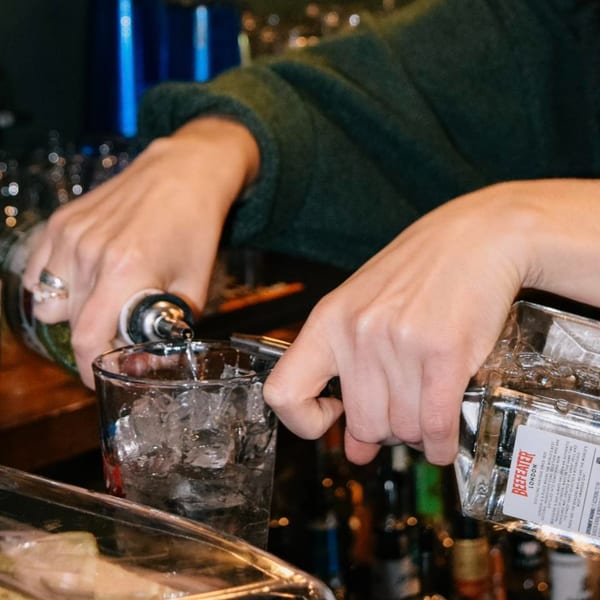 Bartender pouring Beefeater gin into an ice-filled glass at Red Creek Bar & Grill.
